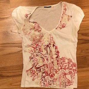 White tee with red and gold metallic print.